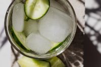Kaboompics - Overhead Close-Up of Cucumber Detox Water with Ice, Glass on Contrasting Marble and Stone in Dappled Sunlight