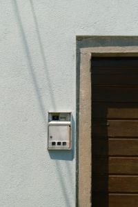 Kaboompics - White Doorbell on Light Blue Stucco Wall with Wooden Door