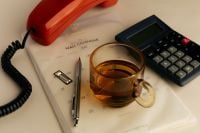 Kaboompics - Retro Office Still Life With Telephone Calculator Calendar and Tea