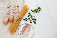 Kaboompics - Spaghetti, Eggs, Bacon and Garlic on White Background