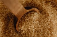 Kaboompics - Horizontal Macro of Brown Sugar Crystals in a Wooden Spoon, Baking Ingredient Texture Background