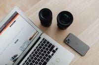 Kaboompics - Camera Lenses and Smartphone Beside Laptop on Light Wood Desk