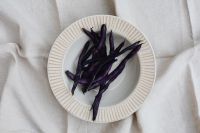 Kaboompics - Overhead Plate of Purple Beans on White Fabric