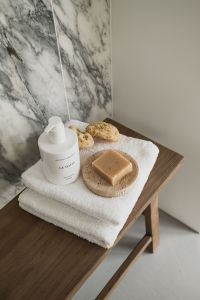 Kaboompics - Wooden Bench with Soap, Towels and Body Brush on Arabescato Wall