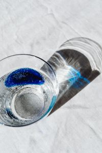 Water Glass Still Life with Blue Accents and Melon for Minimal Drink Editorials
