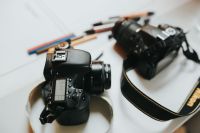 Kaboompics - DSLR Cameras and Camera Strap on Creative Studio Table
