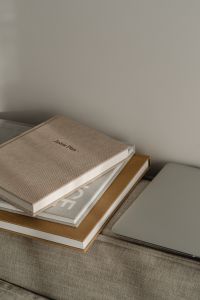 Kaboompics - Minimal Home Office Styling: Laptop, Planner and Books on a Textured Sofa