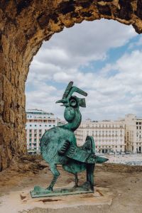 Kaboompics - Bronze Rooster Sculpture Framed by a Stone Arch at Castel dell’Ovo