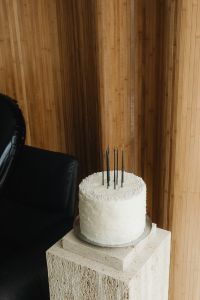 Kaboompics - White Cake with Black Candles on a Stone Pedestal