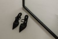 Kaboompics - Black Pointed Slingback Heels on Neutral Floor