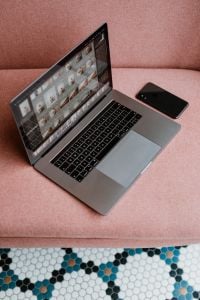 MacBook Pro laptop & iPhone X mobile on a pink sofa