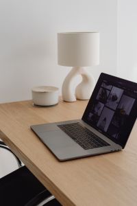 Kaboompics - Laptop And Sculptural Lamp On Wooden Desk With Storage Jar