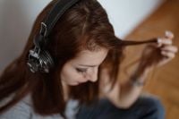 Kaboompics - Beautiful young woman in headphones listening to music