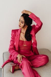 Kaboompics - Woman Sitting on Sofa in Pink Satin Suit