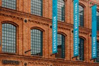Kaboompics - Blue Event Banners against Arched Red-Brick Factory Windows at Manufaktura, Łódź