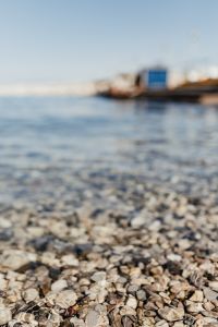 Kaboompics - Soft Focus Pebbles under Clear Seawater with Distant Shore