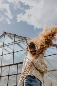 Kaboompics - Side View of Woman Holding Pampas Grass in a Greenhouse