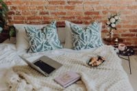 Kaboompics - Laptop and Open Notebook on a Knit Bed with Croissant Breakfast, Cozy Bedroom Work Setup