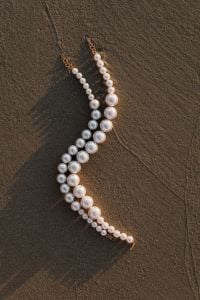 Kaboompics - Layered Pearl Necklaces on Dark Sand, Minimal Jewelry Flat Lay