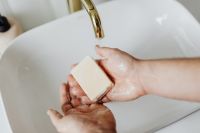 Kaboompics - Close-Up of Bar Soap in Wet Hands beneath a Brass Faucet, Handwashing Education