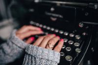 Kaboompics - Woman typing on an old typewriter