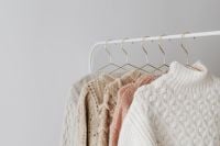 Kaboompics - Pastel Sweaters Hanging on Minimal Clothing Rack