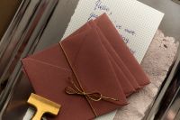 Kaboompics - Burgundy Envelopes Tied with Gold Ribbon and Handwritten Letter
