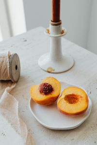 Kaboompics - Peach Halves with White Candle and Rustic Textile Detail