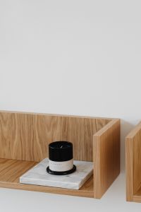 Kaboompics - Vertical Black Candle on Marble Block Against Oak Shelf