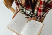 Kaboompics - Open Book on Lap With Plaid Blanket