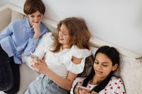 Kaboompics - Teen Friends Sharing Smartphone Moments During a Relaxed Bedside Hangout