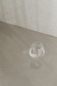 Kaboompics - Minimalist Empty Glass on a Textured Greige Surface with Copy Space