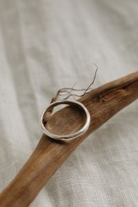 Kaboompics - Single Silver Band Ring on Driftwood with Copy Space