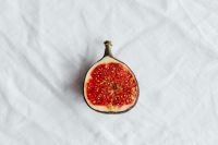 Kaboompics - Single Fresh Fig Cut Open on White Linen Background
