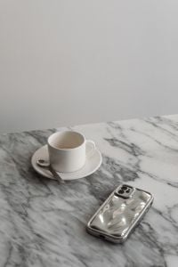 Kaboompics - Vertical White Coffee Cup and Silver Smartphone on Marble with Copy Space