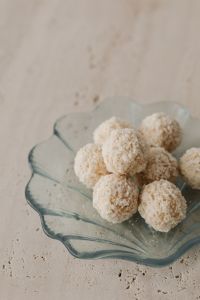 Kaboompics - Close-Up Coconut Truffles in a Scalloped Glass Dish, Soft Neutral Food Photography