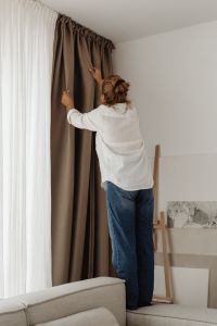 Kaboompics - Woman Opening Floor-to-Ceiling Curtains