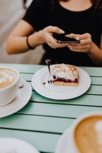 Kaboompics - The woman takes a picture of the cake with her phone