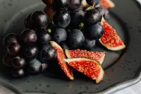 Kaboompics - Dark Grapes and Fresh Fig Slices on a Black Plate
