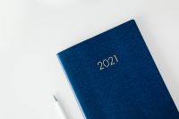 Kaboompics - Navy 2021 Planner and White Pen on a Clean Desk