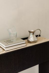 Kaboompics - Silver Pitcher, Glass and Books on Travertine Console