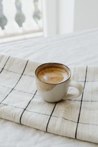 Kaboompics - Coffee Cup on a Folded Checkered Throw