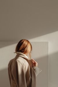Kaboompics - Faceless Woman in Beige Jacket Standing in Sunlight