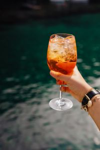 Kaboompics - Drink in Hand against Deep Teal Seawater