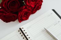 Kaboompics - Red Roses Above Open February Planner and Pen, Valentine's Day Workspace