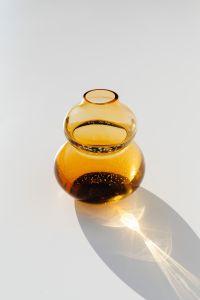 Kaboompics - Sculptural Double-Bulb Amber Glass Vase Casting a Long Shadow