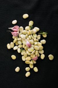 Kaboompics - Pale Beans and Garlic on a Black Background