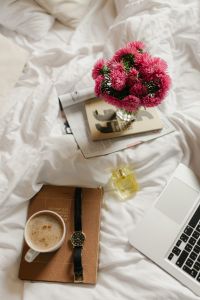 Kaboompics - Aesthetic Bed Flat Lay with Pink Flowers, Coffee, Books and Laptop