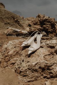 Kaboompics - White Heeled Sandals on Coastal Rocks with Sea Background