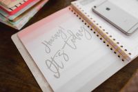 Kaboompics - Pink Happy New Year Planner, Stacked Notebooks and Smartphone on Desk